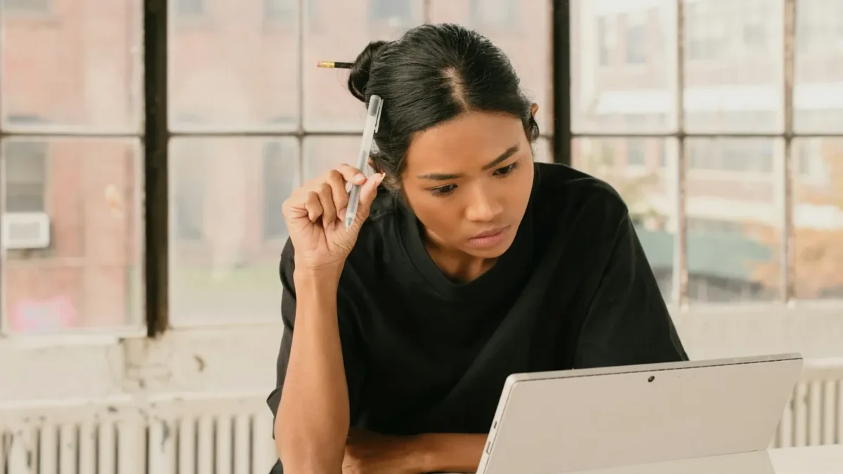 A woman sitting at a table using a laptop computer