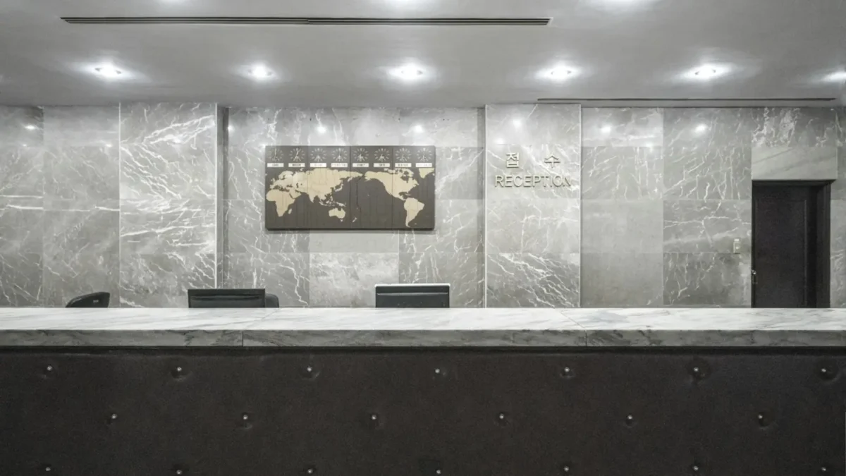 Paper appointment book open on a reception counter beside a phone, for a small business weighing Setmore alternatives
