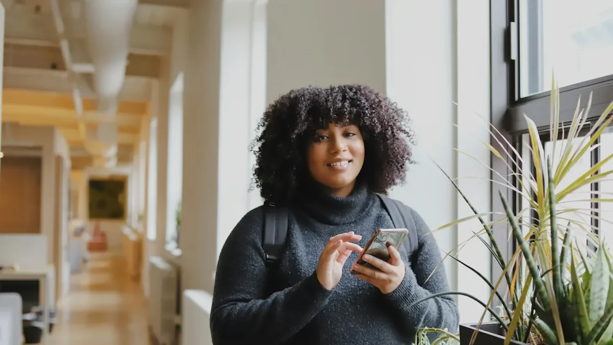 Woman in black long sleeve shirt using smartphone
